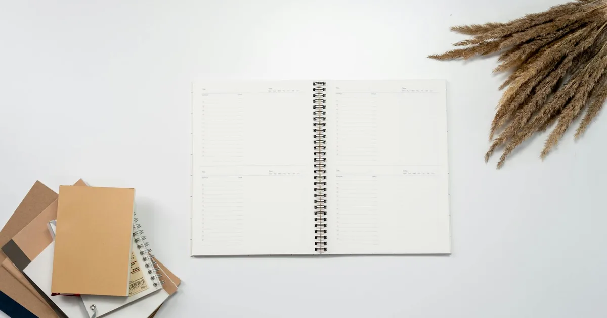 Open notebook with planner pages and pampas grass on a white background, ideal for ADHD productivity themes.