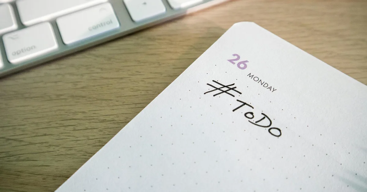 Close-up of a to-do list next to a computer keyboard, symbolizing task initiation and productivity for ADHD planning.